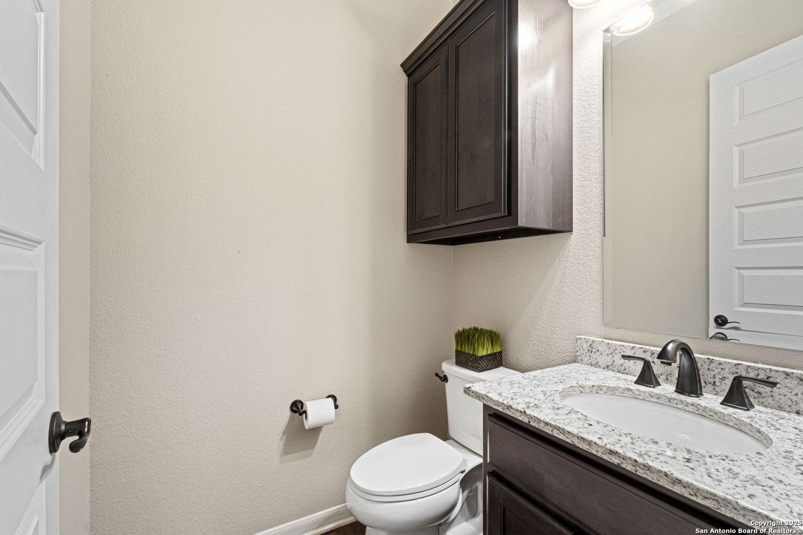 105 Gaucho Boerne, TX 78006 - Photo 24 of 29 a bathroom with a granite countertop sink a toilet and a mirror