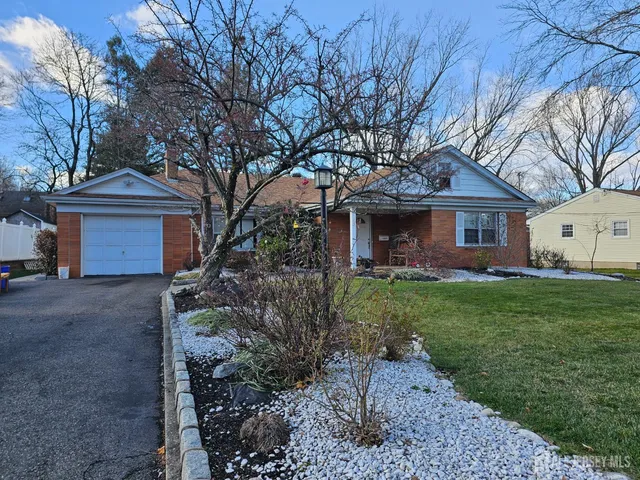 a view of a house with a yard and large tree