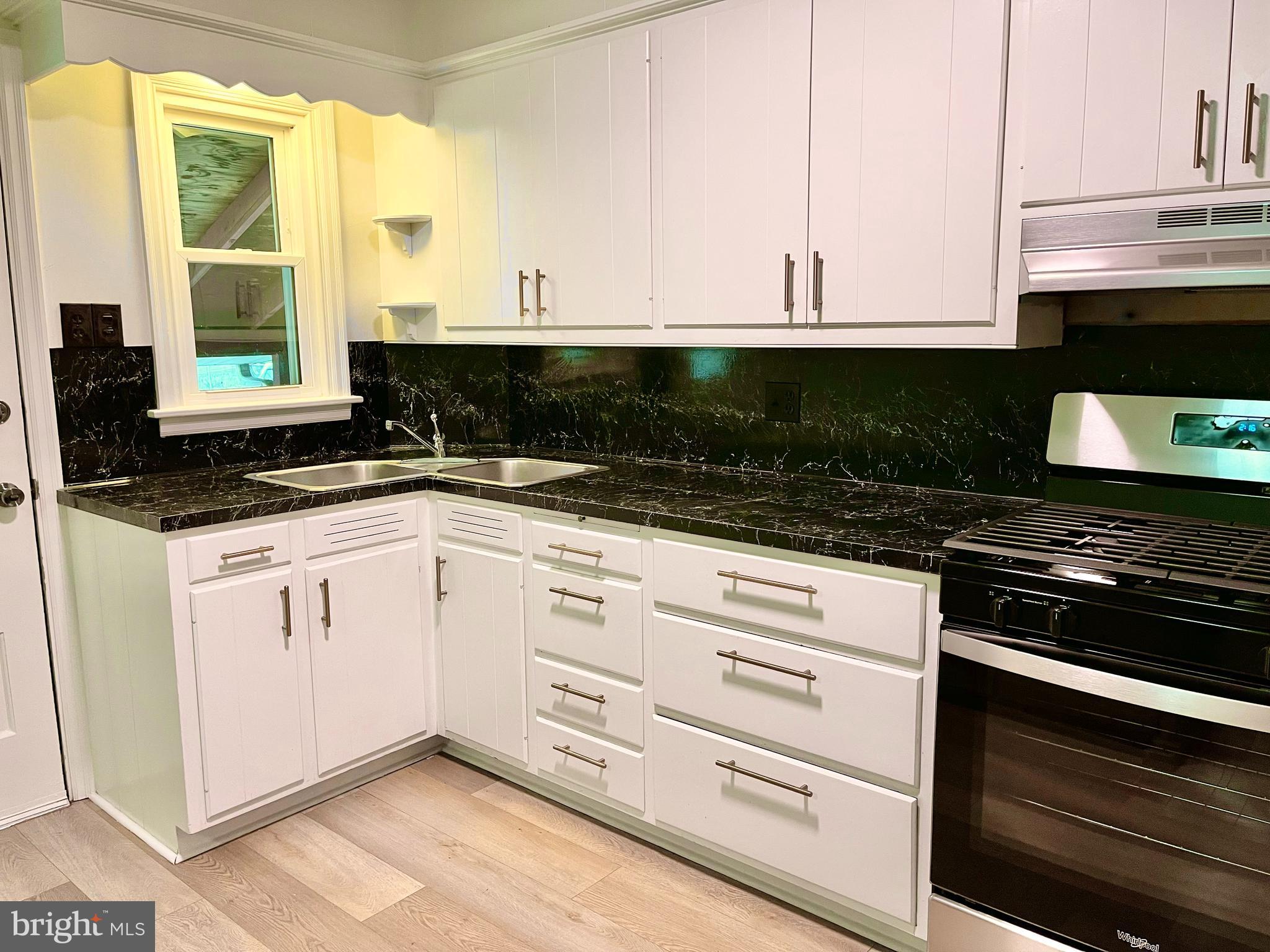 1136 Union Street Lancaster, PA 17603 - Photo 6 of 24 a kitchen with granite countertop white cabinets and black appliances