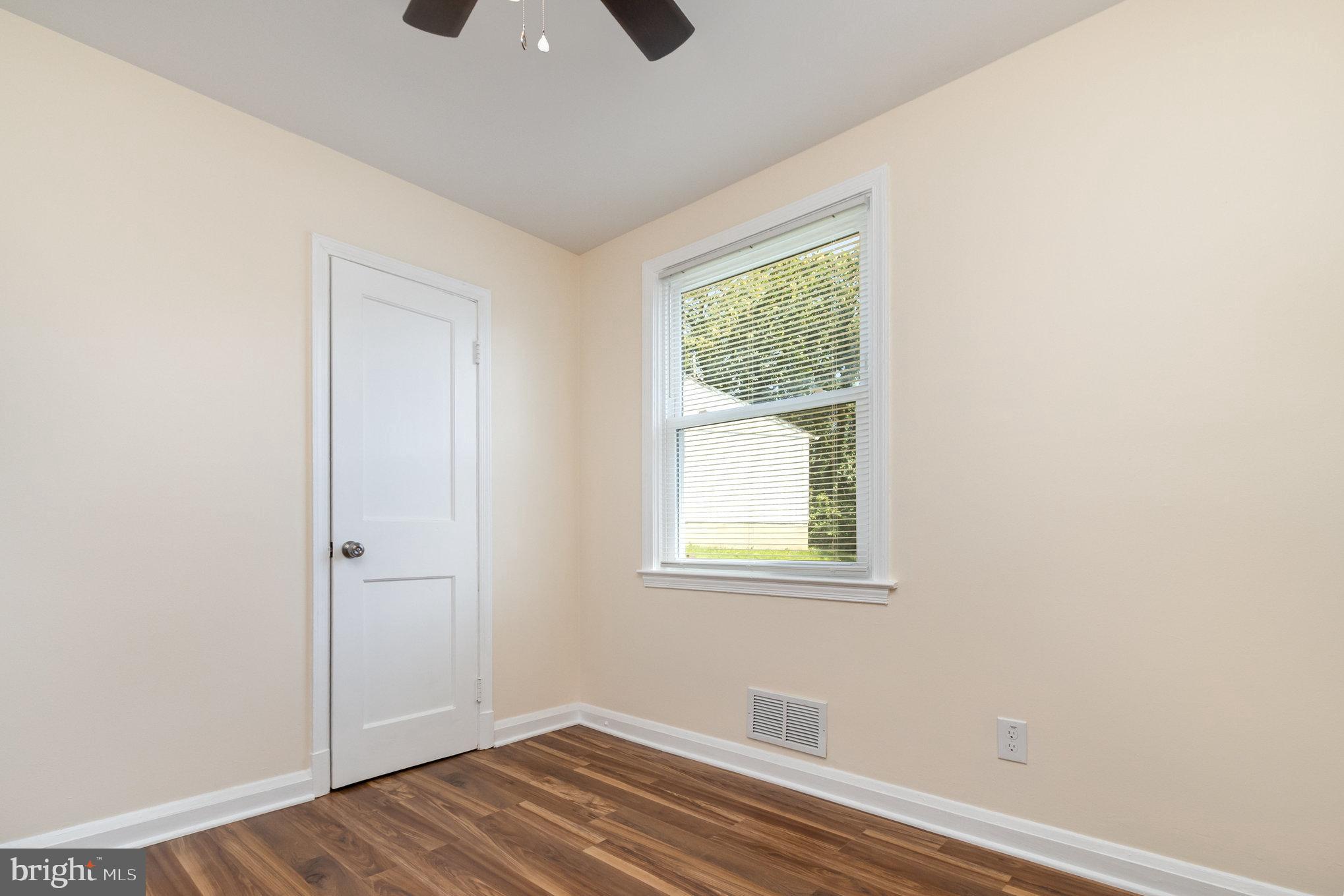 6301 Fieldvale Road Baltimore, MD 21237 - Photo 13 of 44 a view of an empty room with wooden floor and a window