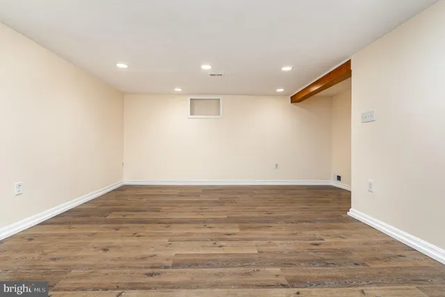 a view of a room with wooden floor and white walls