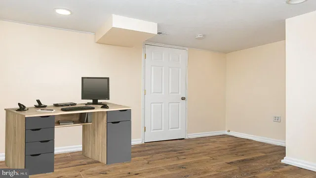 a view of a workspace with furniture and wooden floor