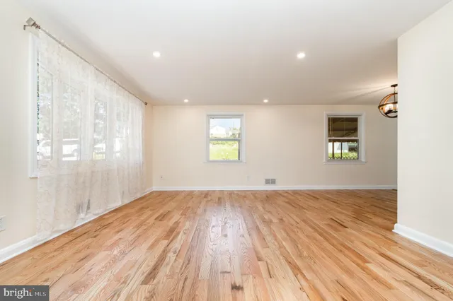 a view of an empty room window and wooden floor