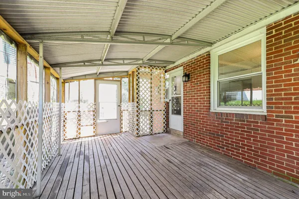 a view of a porch with wooden floor and floor to ceiling window