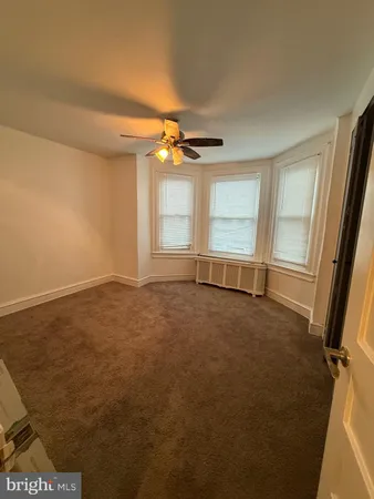 an empty room with a ceiling fan and window