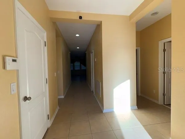 a view of a hallway with closet and a living room