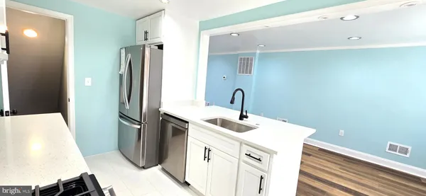 a kitchen with white cabinets and sink