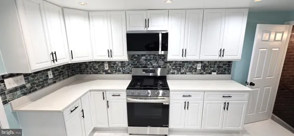 a large kitchen with a stove a sink and a refrigerator