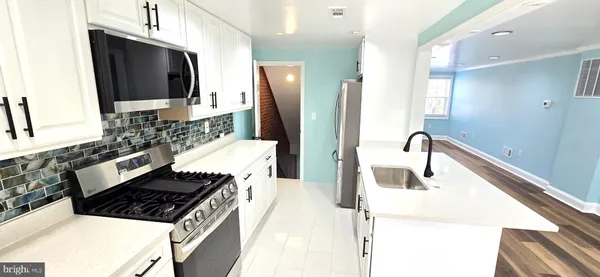 a kitchen with stainless steel appliances kitchen island granite countertop a sink a stove and refrigerator