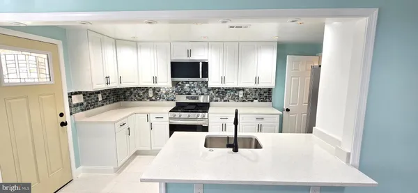 a kitchen with a sink a stove and cabinets