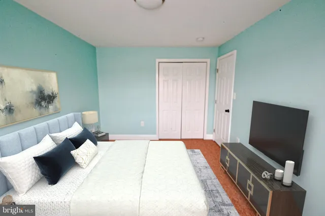a bedroom with bed and a flat tv screen on a dresser