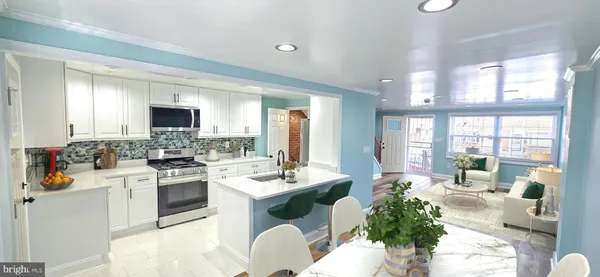 a large white kitchen with stainless steel appliances