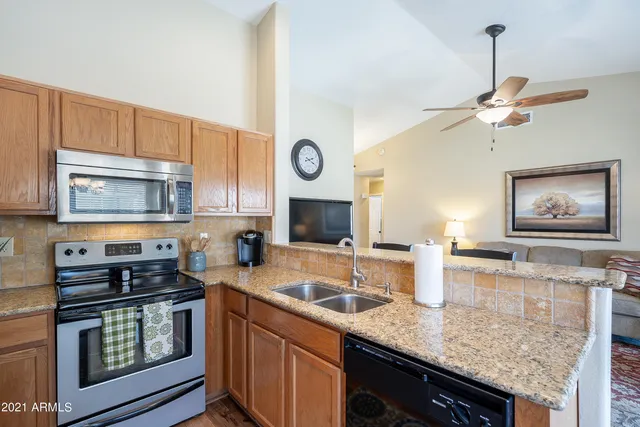 a kitchen with stainless steel appliances granite countertop a sink a stove and cabinets