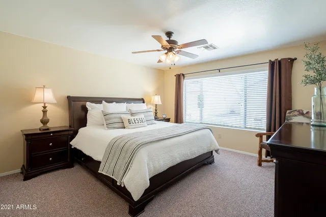 a bedroom with a bed and a flat tv screen on the dresser