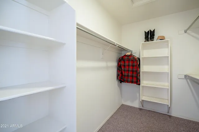 a view of walk in closet with clothes