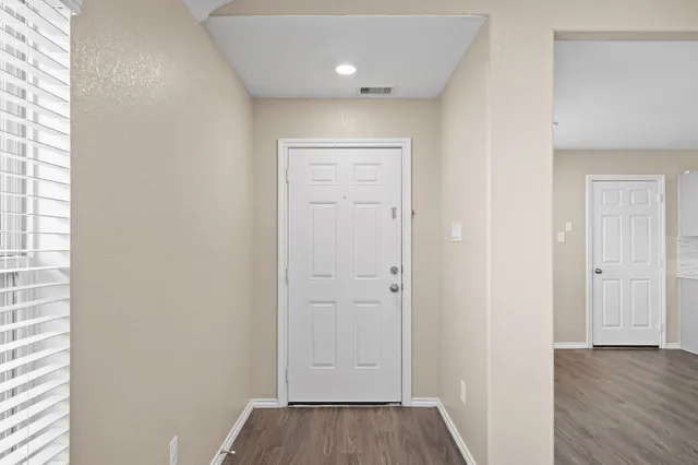 a view of a hallway with wooden floor