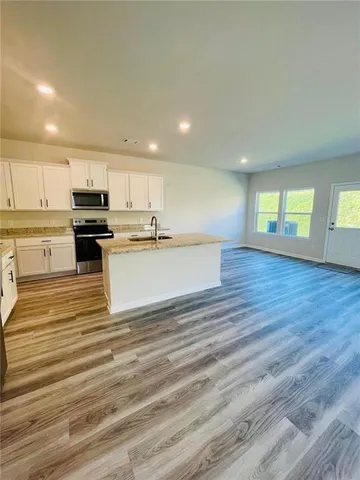 a kitchen with stainless steel appliances granite countertop a stove a sink and a refrigerator