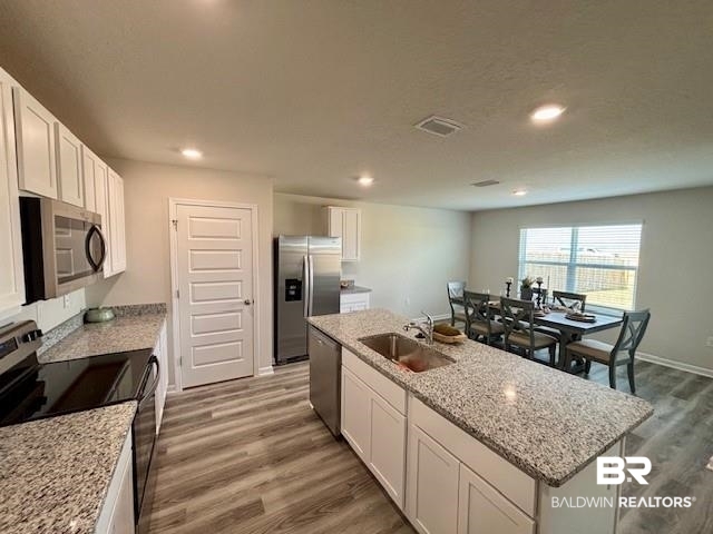 22215 Aleutian Avenue Foley, AL 36535 - Photo 7 of 34 Kitchen featuring white cabinetry, a kitchen island with sink, sink, and stainless steel appliances