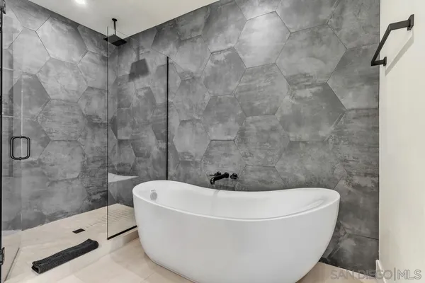 a white bath tub sitting in a bathroom and shower