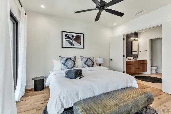 a bedroom with a large bed and a chandelier