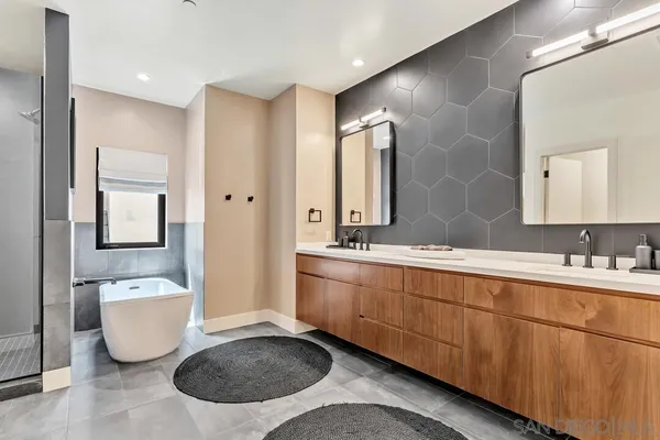 a spacious bathroom with a double vanity sink mirror and bathtub