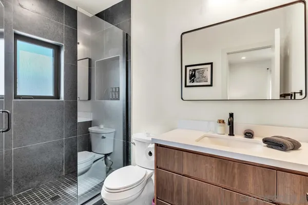 a bathroom with a toilet a sink and mirror