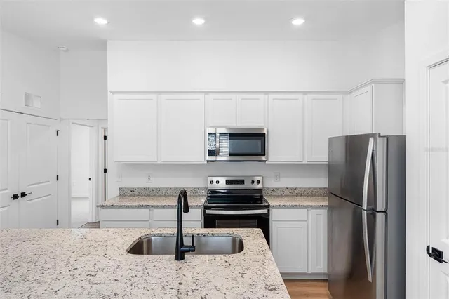 a kitchen with refrigerator a microwave a sink and a stove
