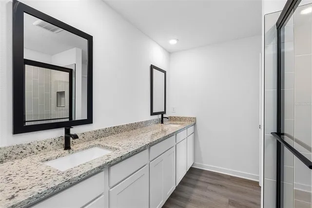 a bathroom with a granite countertop sink and a mirror