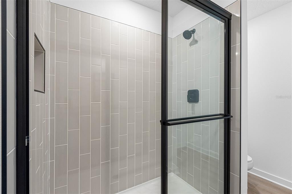 11497 Marvelwood Road Brooksville, FL 34614 - Photo 9 of 9 a bathroom with a glass shower door