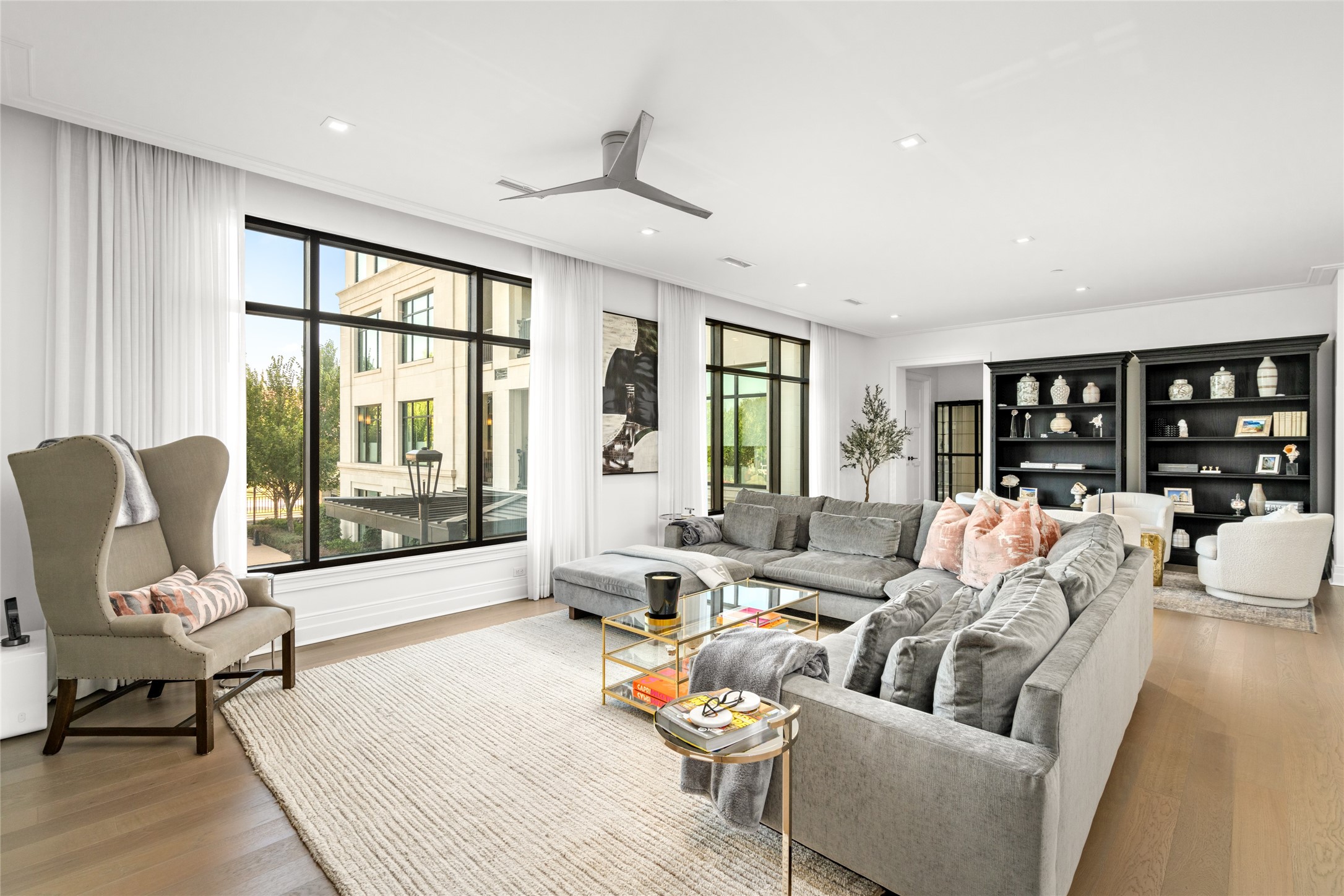 6017 Memorial Drive, Unit 202 Houston, TX 77007 - Photo 2 of 36 A wall of windows fill the expansive living room with natural light to add to the warm living space highlighting the custom drapes and 7” decorative baseboards.