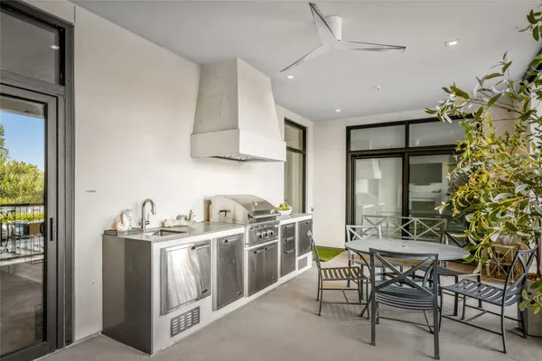 a kitchen with stainless steel appliances a table and chairs in it