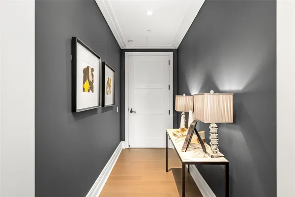 a view of a hallway with wooden floor and chair