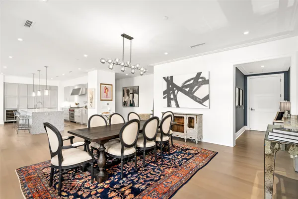 a dining room with furniture wooden floor a rug and a chandelier