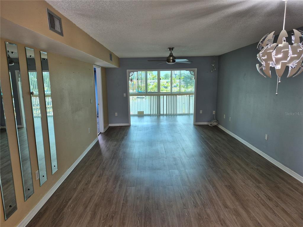 4939 Floramar Terrace, Unit 203 New Port Richey, FL 34652 - Photo 7 of 16 a view of an empty room with wooden floor and a window