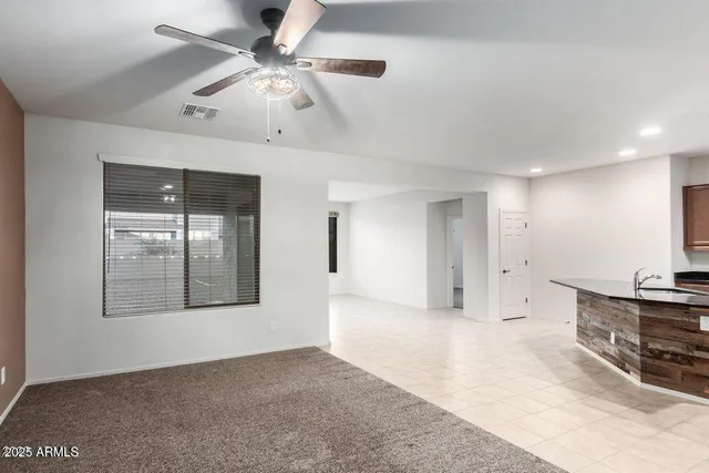 a view of an empty room with a window and a kitchen