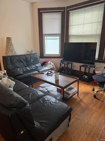 a living room with a fireplace and wooden floor
