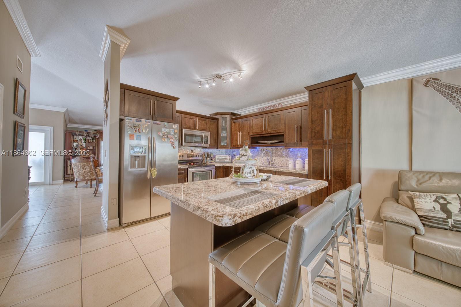 16886 Southwest 143rd Place Miami, FL 33177 - Photo 13 of 39 a kitchen with stainless steel appliances granite countertop sink refrigerator and cabinets