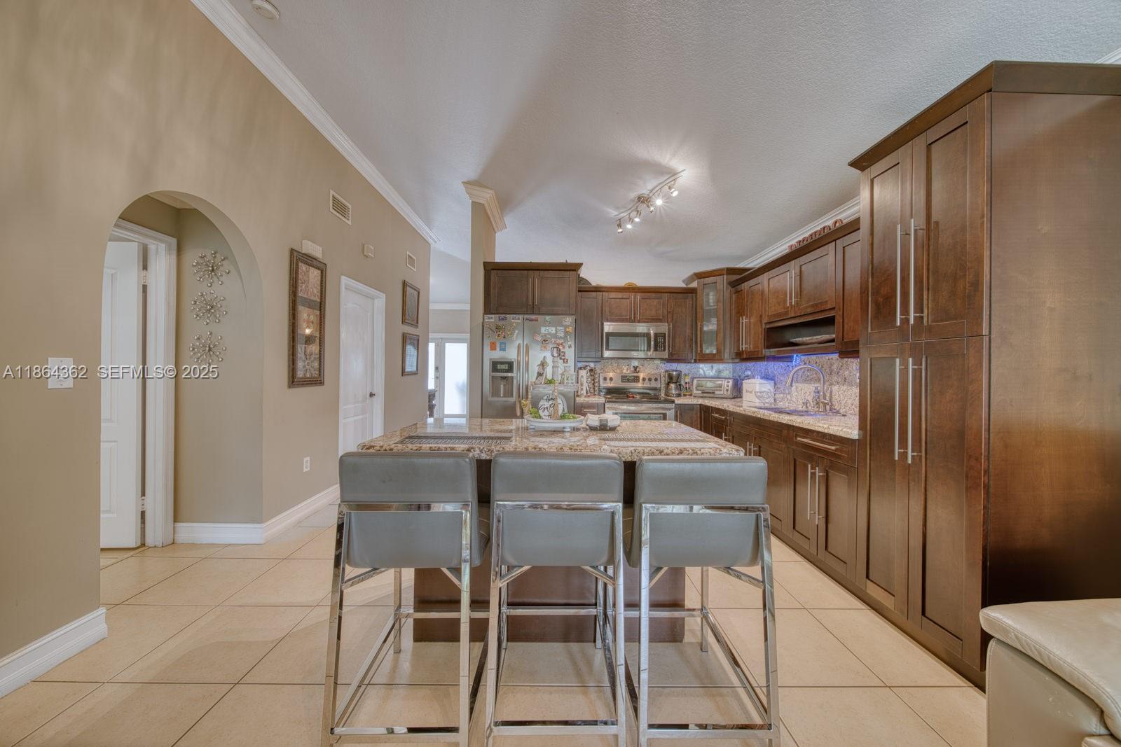 16886 Southwest 143rd Place Miami, FL 33177 - Photo 14 of 39 a kitchen with granite countertop cabinets and refrigerator