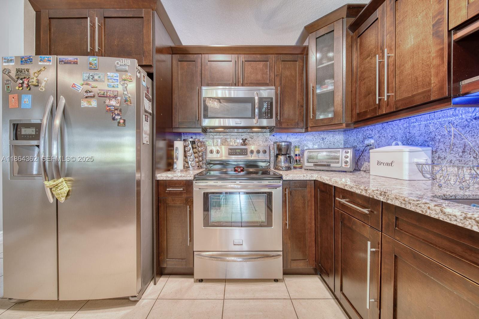 16886 Southwest 143rd Place Miami, FL 33177 - Photo 16 of 39 a kitchen with stainless steel appliances granite countertop a refrigerator and a sink