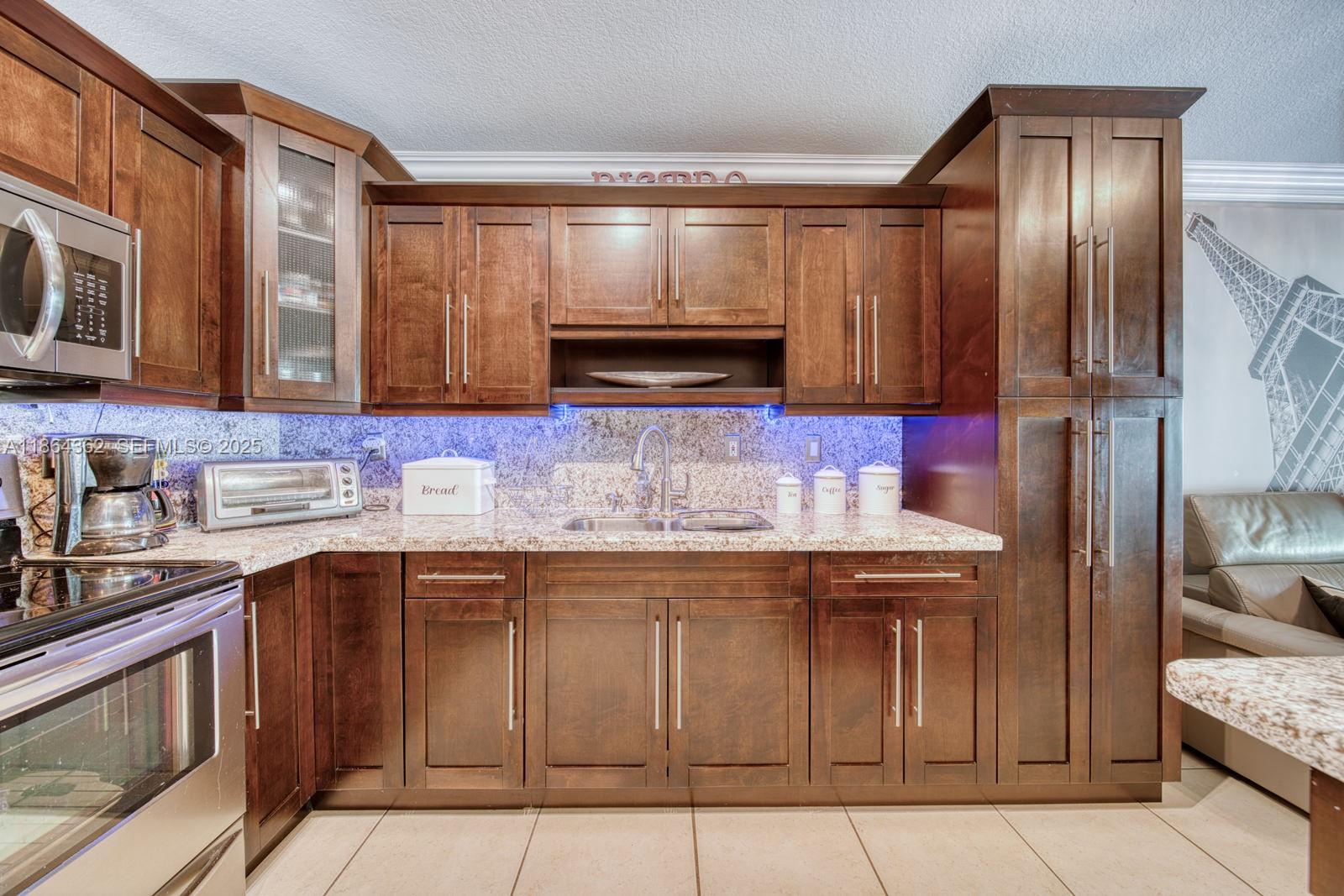 16886 Southwest 143rd Place Miami, FL 33177 - Photo 17 of 39 a kitchen with stainless steel appliances granite countertop a sink and a refrigerator