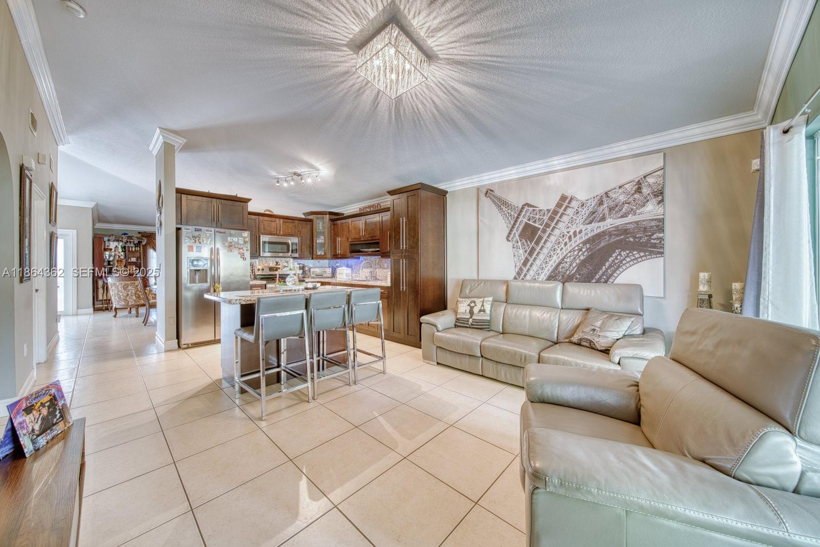 16886 Southwest 143rd Place Miami, FL 33177 - Photo 19 of 39 a living room with furniture and a dining table with kitchen view