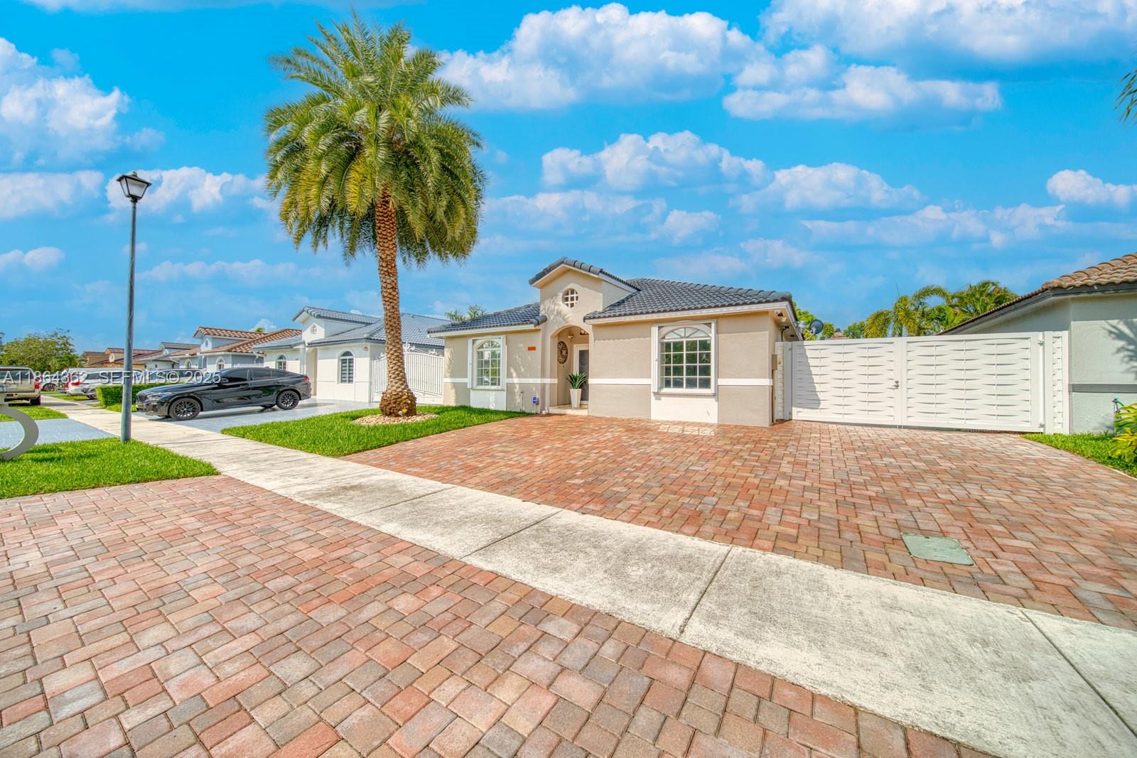 16886 Southwest 143rd Place Miami, FL 33177 - Photo 2 of 39 a front view of house with yard and green space