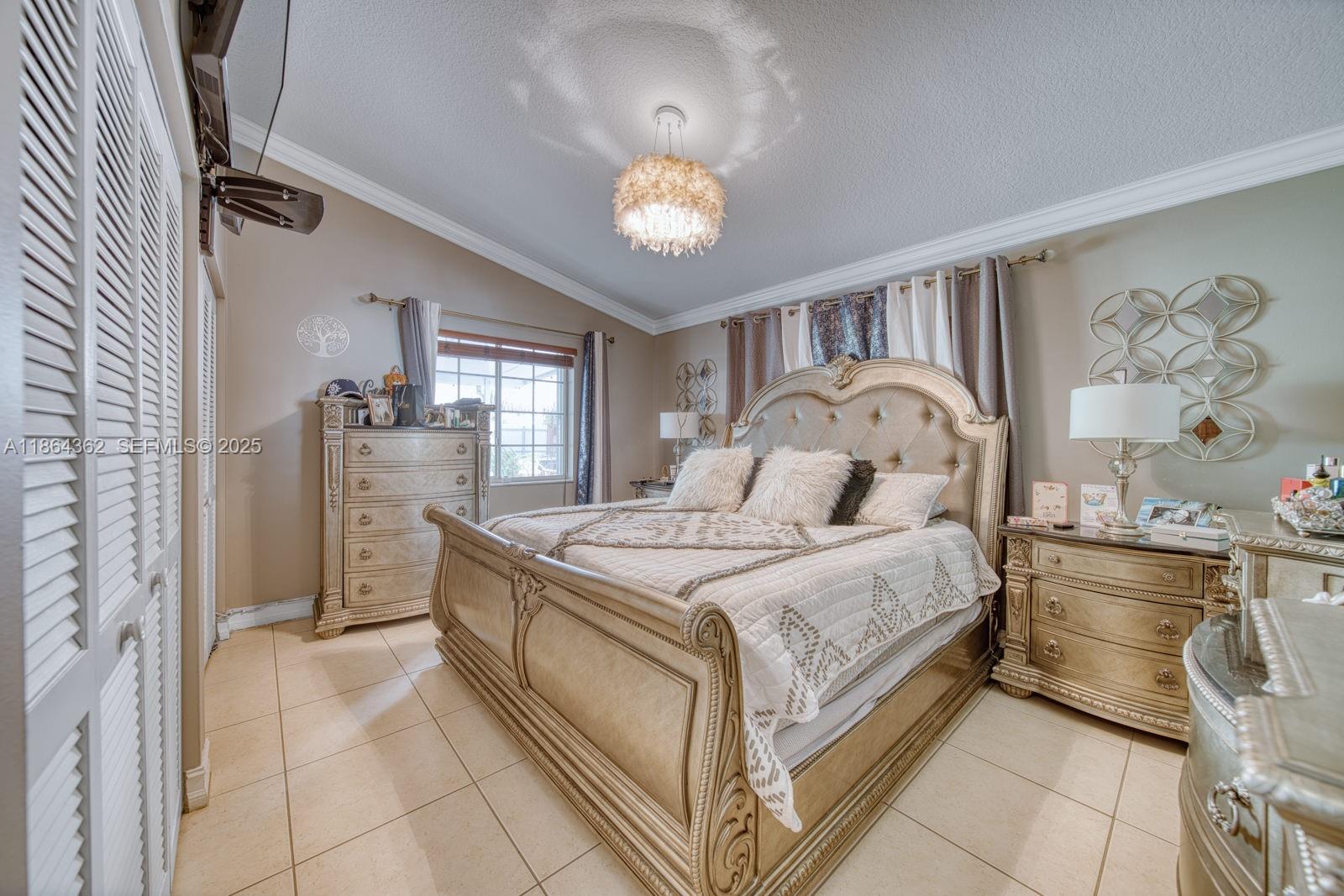 16886 Southwest 143rd Place Miami, FL 33177 - Photo 23 of 39 a bedroom with a bed and a chandelier