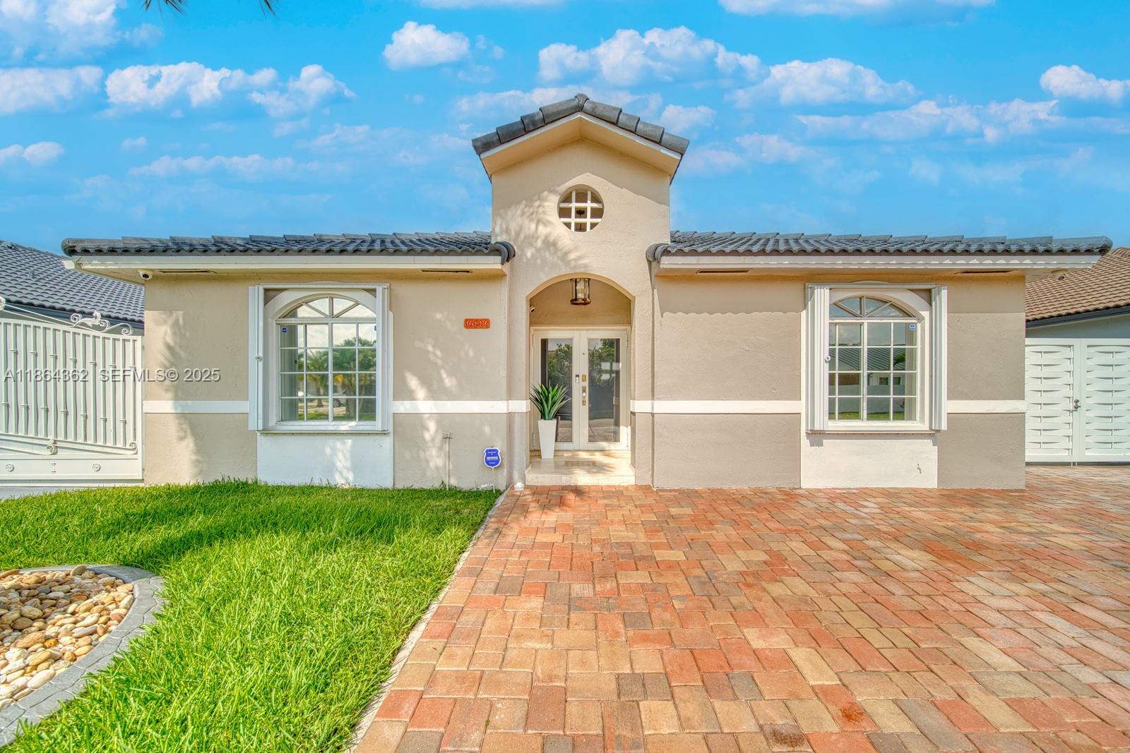 16886 Southwest 143rd Place Miami, FL 33177 - Photo 3 of 39 a front view of a house with a garden
