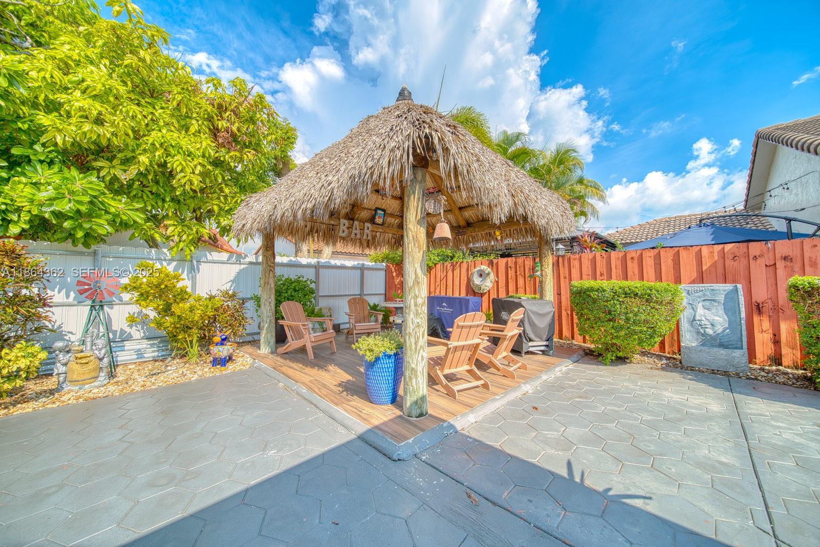 16886 Southwest 143rd Place Miami, FL 33177 - Photo 34 of 39 a view of a patio with a table and chairs under an umbrella