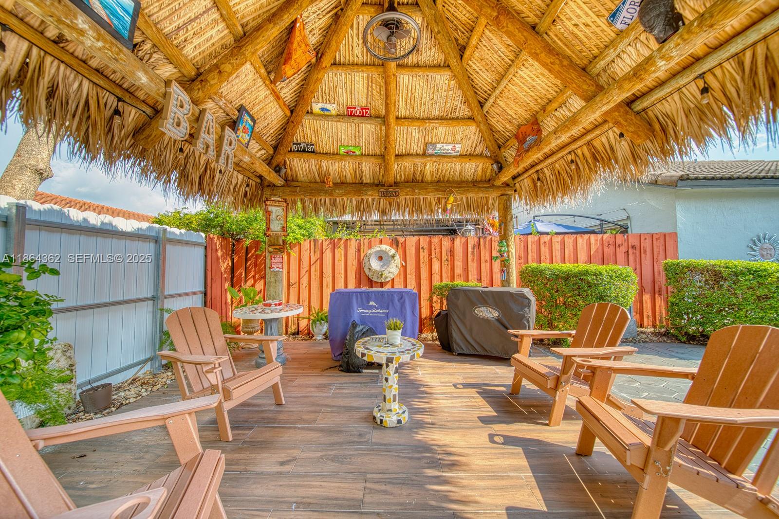 16886 Southwest 143rd Place Miami, FL 33177 - Photo 36 of 39 a view of a chairs and table in patio with a fire pit and wooden fence