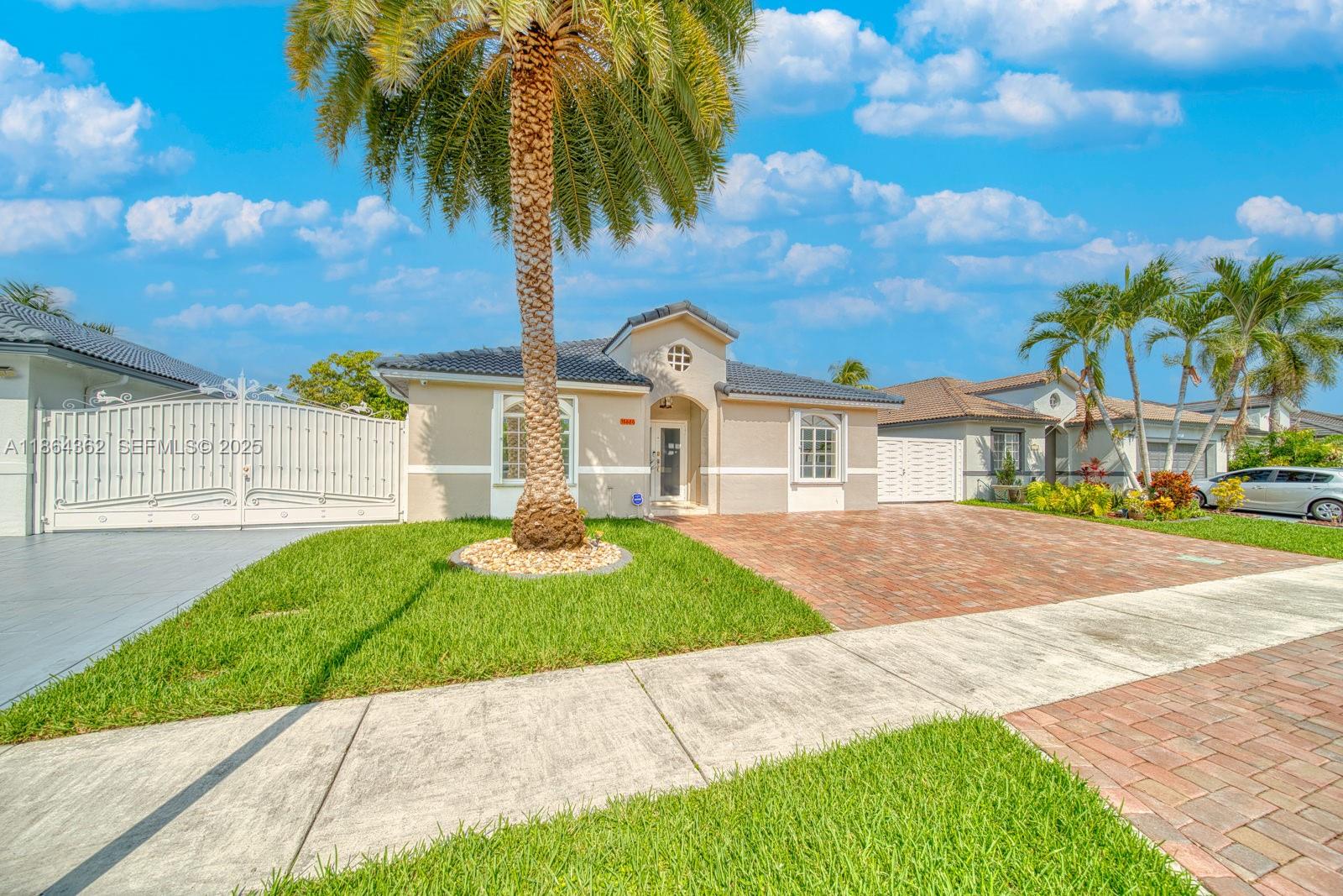 16886 Southwest 143rd Place Miami, FL 33177 - Photo 4 of 39 a front view of a house with a yard and garage