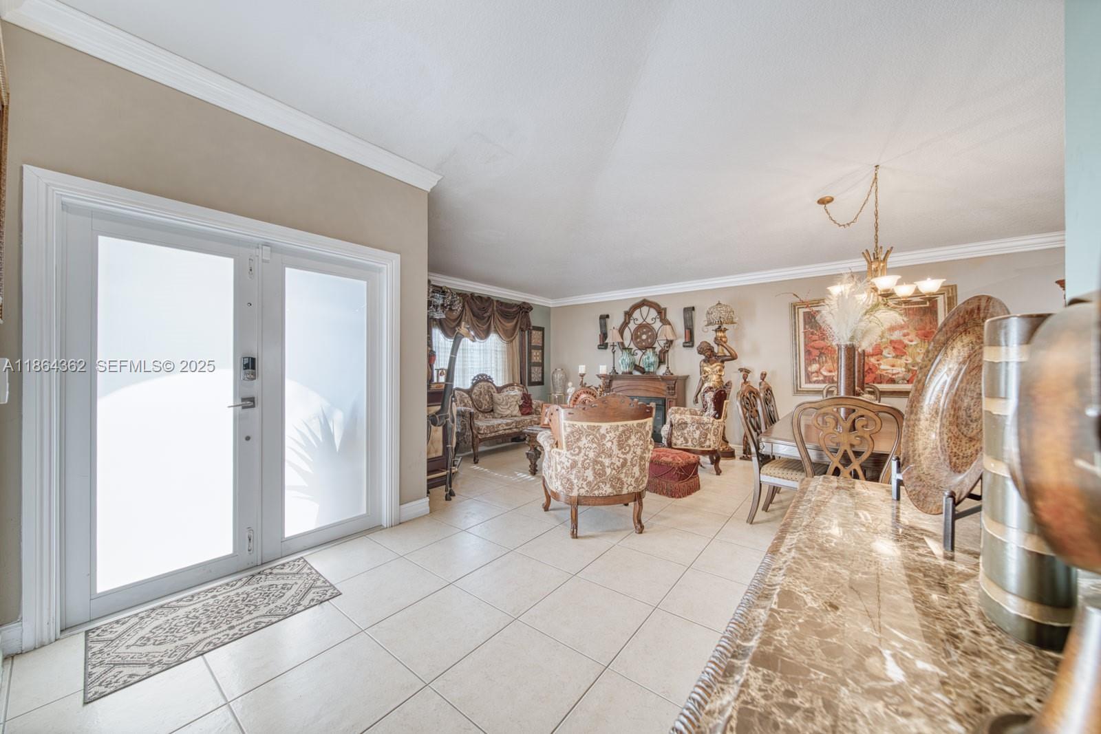 16886 Southwest 143rd Place Miami, FL 33177 - Photo 6 of 39 a living room with furniture and a chandelier
