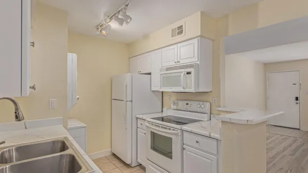 a kitchen with white cabinets and white appliances