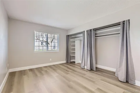 an empty room with windows and closet